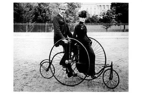 Altes Foto Mann und Frau auf Fahrrad stehend mit Stützrädern vorne und hinten (Neudruck als Postkarte)
