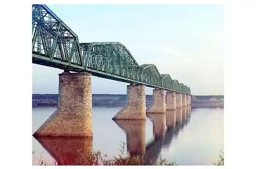 Altes Farbfoto Transsibirische Eisenbahn-Metallfachwerkbrücke auf Steinpfeilern über den Kama River in der Nähe von Perm im Ural (Neudruck als Postkarte)