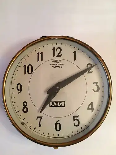 &quot;Uhr, Peter Behrens (1868  1940), Entwurf 1910 für AEG Berlin, Metallblech dunkel patiniert, Messing , farbloses Glas, weißes Ziffernblatt mit schwarzem Zahlung, Höhe 11...