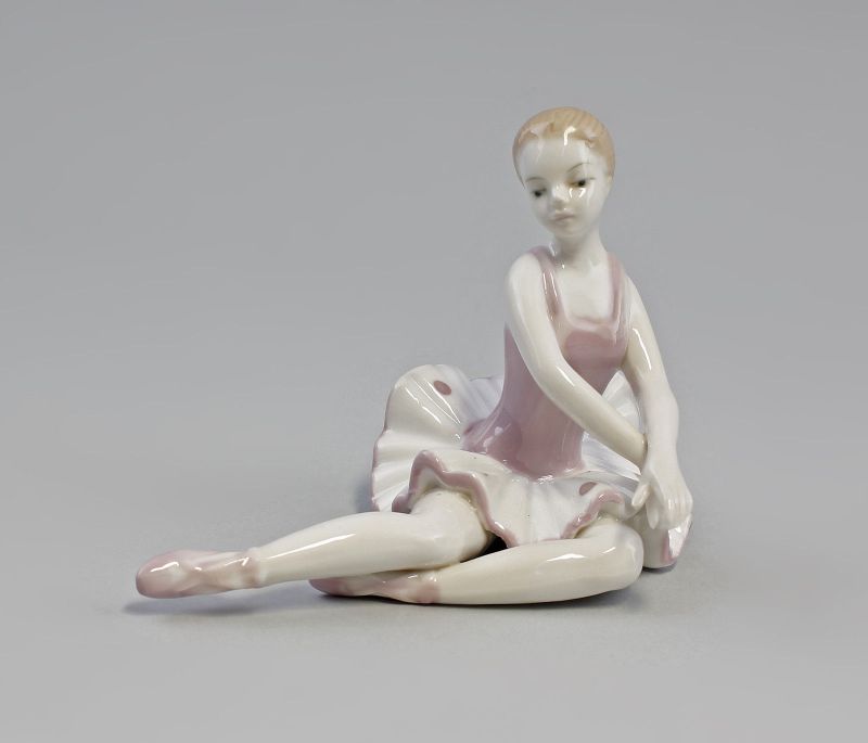 EINE PORZELLANFIGUR EINE SITZENDE BALLERINA IN BLAU