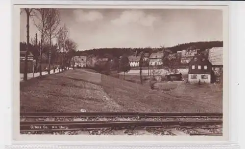 904417 Ak Grüna - Am Berg, Straßenansicht mit Schienen und Allee