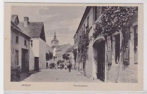 91354 AK Jessen - Fischergasse, Straßenansicht mit Passanten und Kirche um 1910