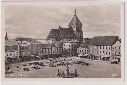 906618 AK Köslin (Koszalin) - Markt mit Geschäften und Kirche