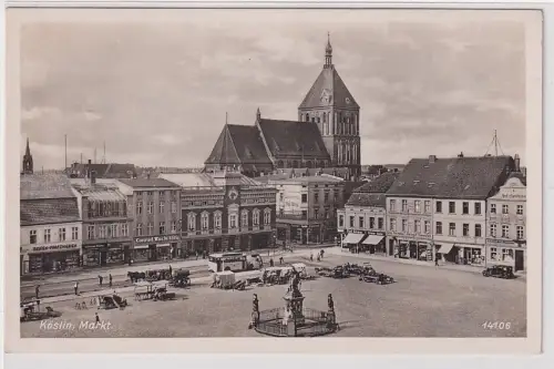 906618 AK Köslin (Koszalin) - Markt mit Geschäften und Kirche