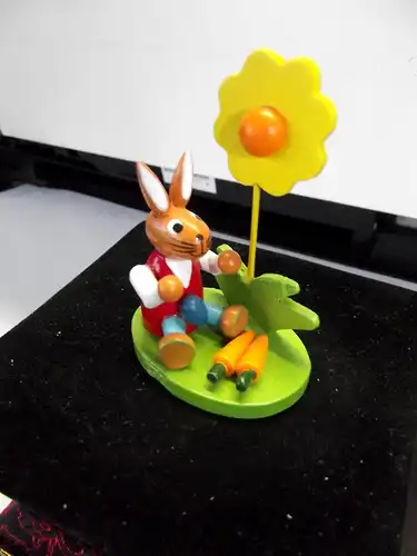 Erzgebirge Volkskunst Ostern ; Osterhase sitzt mit Möhren vor einer Sonnenblume