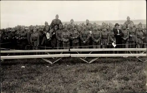 Foto Ak Gruppenbild Schweizer Soldaten in Uniform hinter einer Absperrung, Mann mit Anzug und Melone