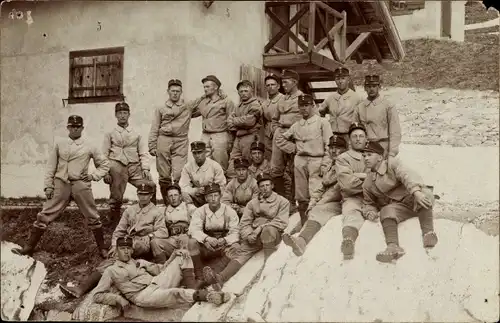 Foto Ak Gruppenbild Schweizer Soldaten in Uniform auf einem Felsen vor einem Haus, Alpenjäger