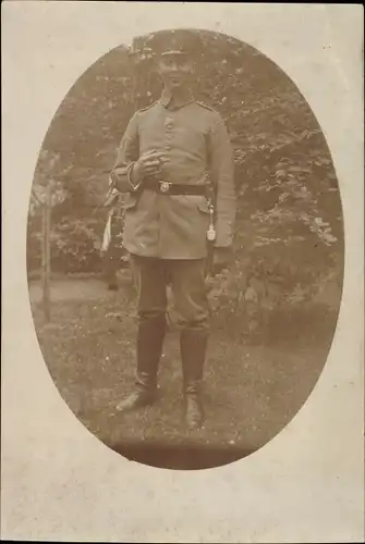 Foto Ak Deutscher Soldat in Uniform, Standportrait, Schirmmütze, Zigarre, Quaste, Stiefel, I. WK