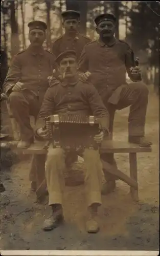 Foto Ak Vier Soldaten in Uniform in der Freizeit mit Ziehharmonika, Pfeife rauchend