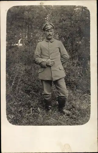 Foto Ak Deutscher Soldat in Uniform, Standportrait, Stiefel, Schirmmütze, Zigarre, I. WK