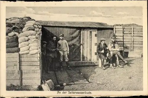 Ak An der Selterwasserbude, Soldaten vor einer Hütte, Sandsäcke, I. WK