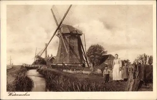 Ak Niederlande, Watermolen, Familie am Bachufer vor einer Windmühle