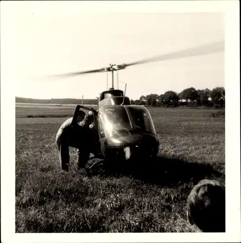 Foto Hubschrauber auf einem Feld, Gespräch der Piloten vor dem Start