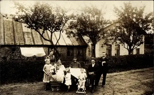 Foto Ak Fleckeby in Schleswig Holstein, Gruppenbild, Familie vor ihrem Haus, Kinderwagen, Holzpferd