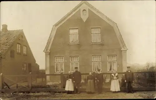 Foto Ak Neumünster in Schleswig Holstein, Blick auf eine Familie vor ihrem Haus