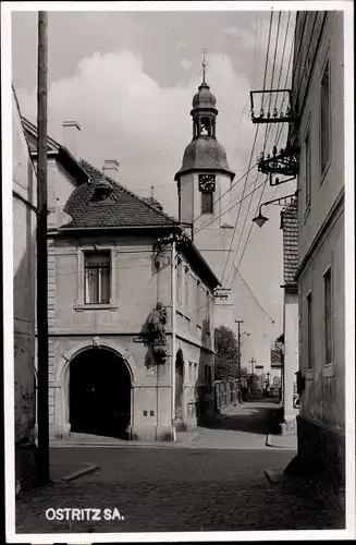 Foto Ak Ostritz in der Oberlausitz, Blick durch eine Gasse im Ort zur Kirche, Zittauer Straße