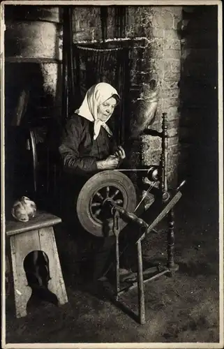 Foto Ak Alte Frau an einem Spinnrad, Szene von einem Bauernhof