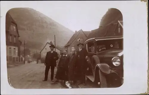 Foto Ak Familienportrait an einem Automobil, Straßenszene