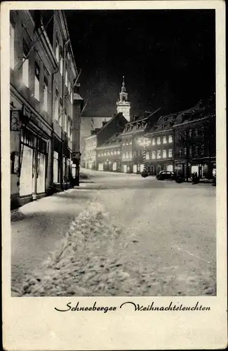 Ak Schneeberg im Erzgebirge, Schneeberger Weihnachtsleuchten, verschneite Straße bei Nacht