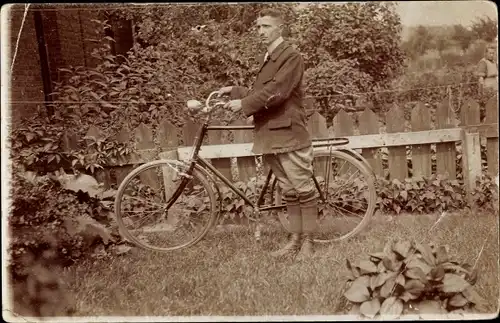 Foto Ak Mann mit einem Fahrrad im Garten