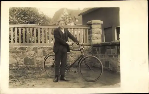 Foto Ak Junger Mann mit einem Fahrrad, Garten