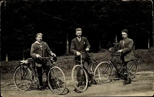 Foto Ak Drei Männer mit Fahrrädern, Hosenklammer