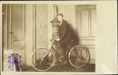 Foto Ak Mann auf einem Fahrrad, Kaminofen
