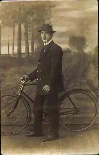 Foto Ak Mann mit Fahrrad, Standportrait, Mütze