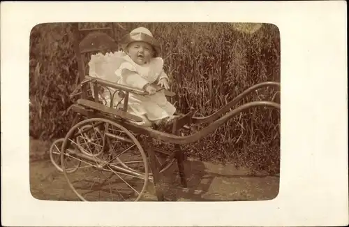 Foto Ak Kleinkind in einem Kinderwagen, Mütze