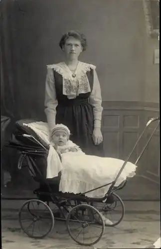 Foto Ak Kind im Kinderwagen, Frau im Kleid, Kragen, Brosche