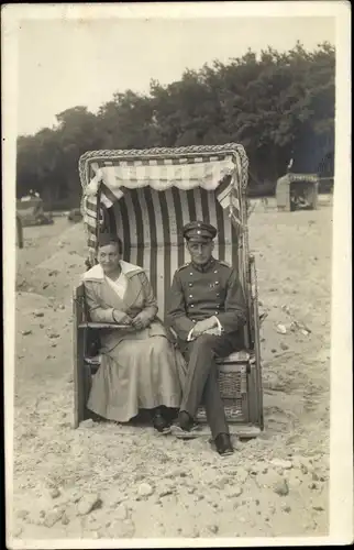 Foto Ak Deutscher Soldat in Uniform, Mit Frau in einem Strandkorb sitzend