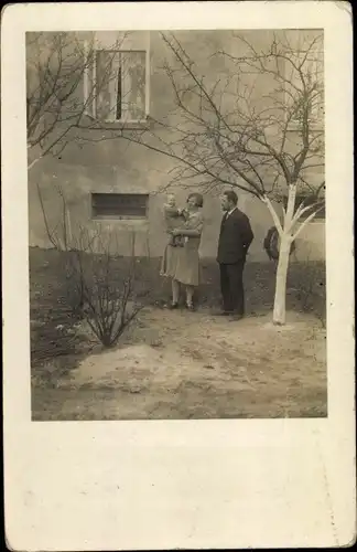 Foto Ak Wilhelmshaven in Niedersachsen, Mann u. Frau m. Kind vor Wohnhaus