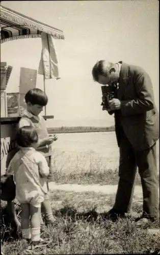 Foto Ak Fotoapparat, Mann mit Kamera fotografiert zwei Kinder, Eiswagen