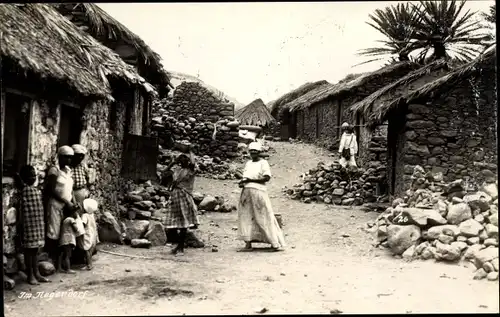 Foto Ak Deutsche Kolonien, Afrikanisches Dorf, Steinhütten, Anwohner