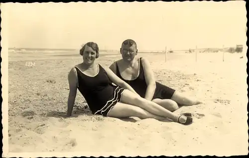 Foto Ak Mann und Frau in Badeanzügen am Strand im Sand liegend