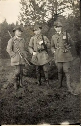 Foto Ak Drei Jäger mit Gewehren auf einer Wiese, Stiefel, Portrait