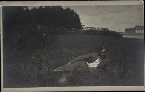 Foto Ak Deutschland?, Mann liegt im Gras, Brille, Brücke