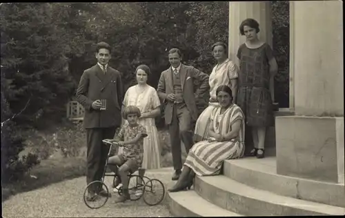 Foto Ak Kind auf einem Dreirad, Familie auf Eingangstreppe, Portal, Garten