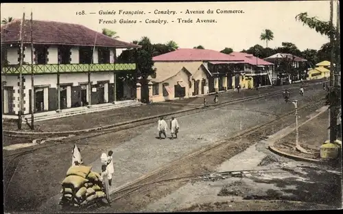 Ak Konakry Conakry Guinea, Avenue du Commerce, vue générale, rails, piétons, maisons