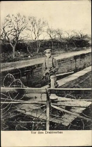 Ak Vor dem Drahtverhau, Deutscher Soldat in Uniform, Gewehr, Schützengraben