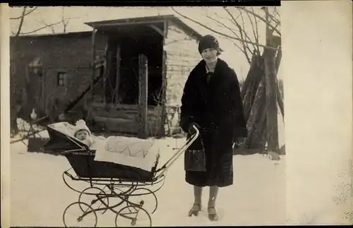 Foto Ak Mutter m. Baby in Kinderwagen, Spaziergang im Winter, Schneelandschaft