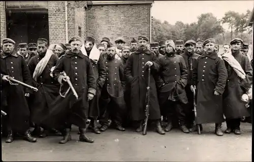 Foto Ak Deutsche Soldaten in Uniformen, Gruppenporträt mit Kriegsverletzten, Kriegsgefangene