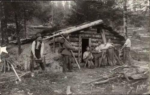 Foto Ak Männer vor einer Holzhütte im Wald