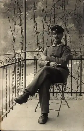 Foto Ak Deutscher Soldat in Uniform, Sitzportrait, Schirmmütze