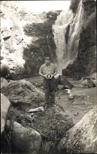 Foto Ak Mann mit Fotoapparat an einem Wasserfall