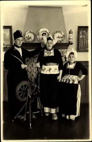 Foto Ak Familie in niederländischen Volkstrachten, Spinnrad