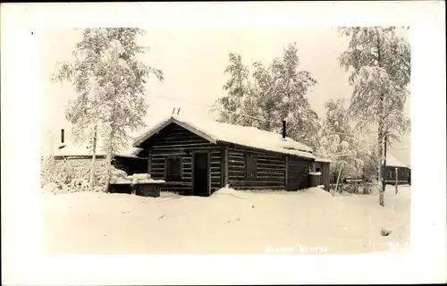 Foto Ak Alaska USA, Blick auf eine Holzhütte im Winter