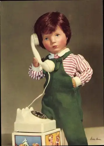 Ak Käthe Kruse Puppen, Junge in Latzhose mit einem Telefon