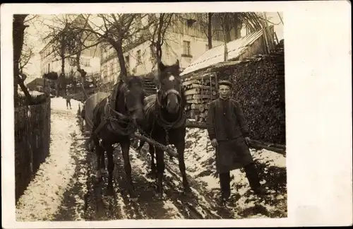 Foto Ak Kutscher neben Pferdefuhre, Schneelandschaft, Winter