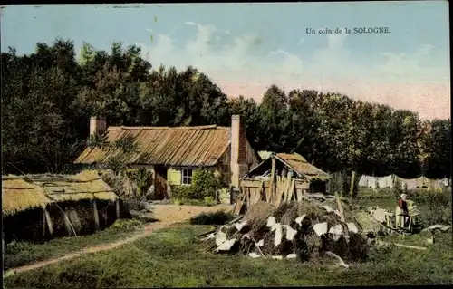 Ak Loiret, Un coin de la Sologne, Frau hängt Wäsche auf, Hütten